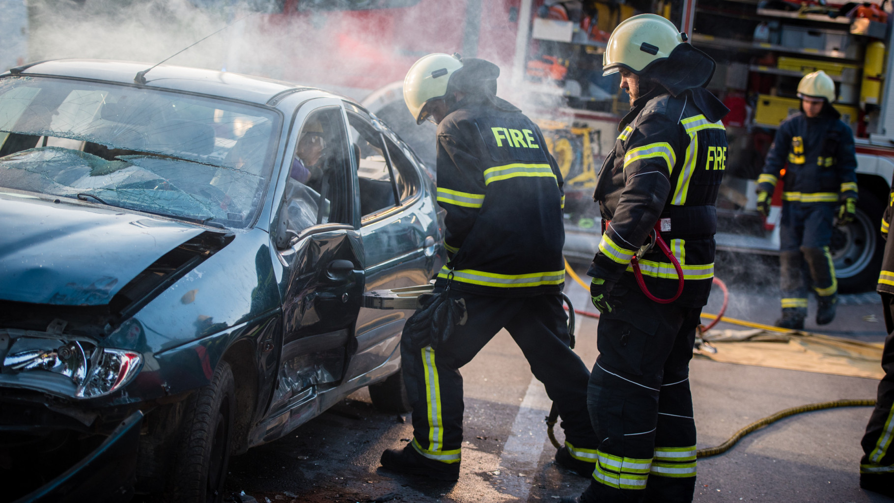 Firefighters trying to get a man out of a damaged car